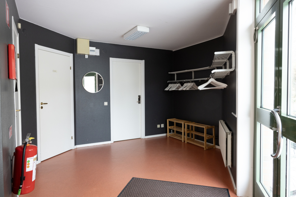 Kvarterslokal Kardusen: Innanför entrén. Kapprum och tre dörrar.