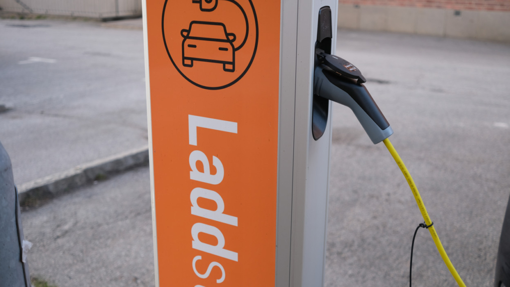 En laddstolpe med en skylt som anger att den driftas av Hyresbostäder.