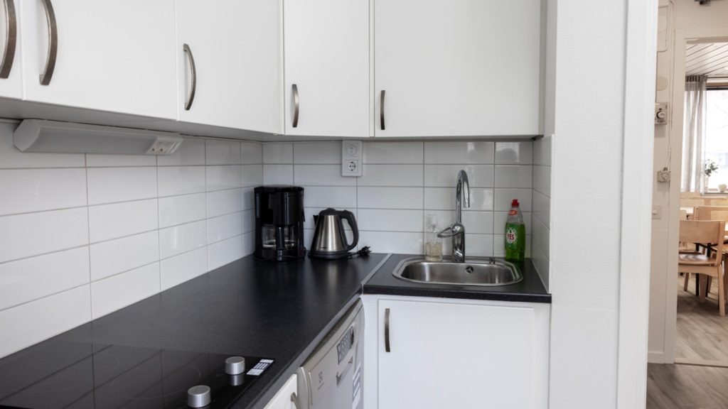 Interiörbild Kvarterslokal Sekreteraren: kök med diskho, kaffebryggare, tekokare och spis med två plattor.