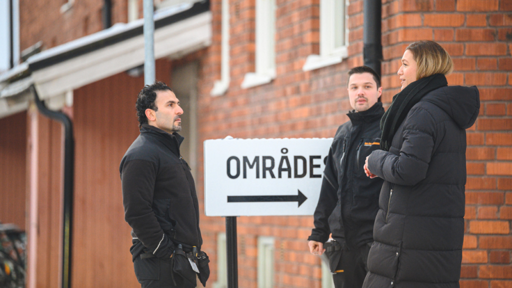 Tre medarbetare på Hyresbostäder står utomhus och konverserar.