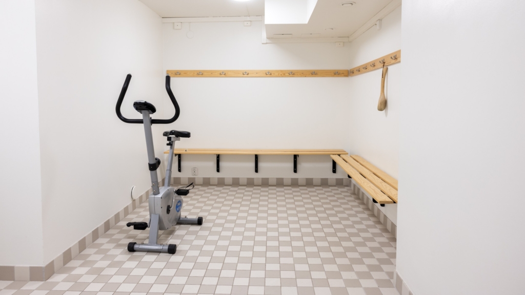 Ett gym med bänk och motionscykel.