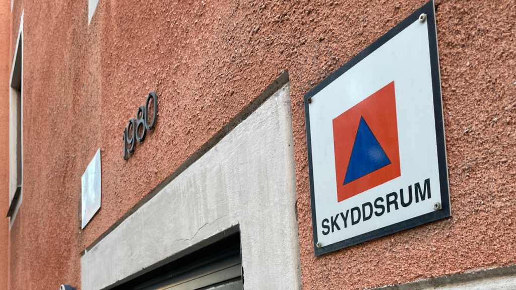 En fasad på lägenhetshus med skylten "skyddsrum".