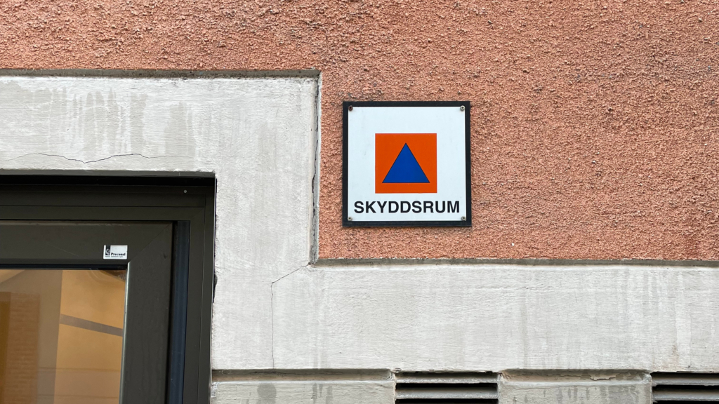 En fasad på lägenhetshus med skylten "skyddsrum".